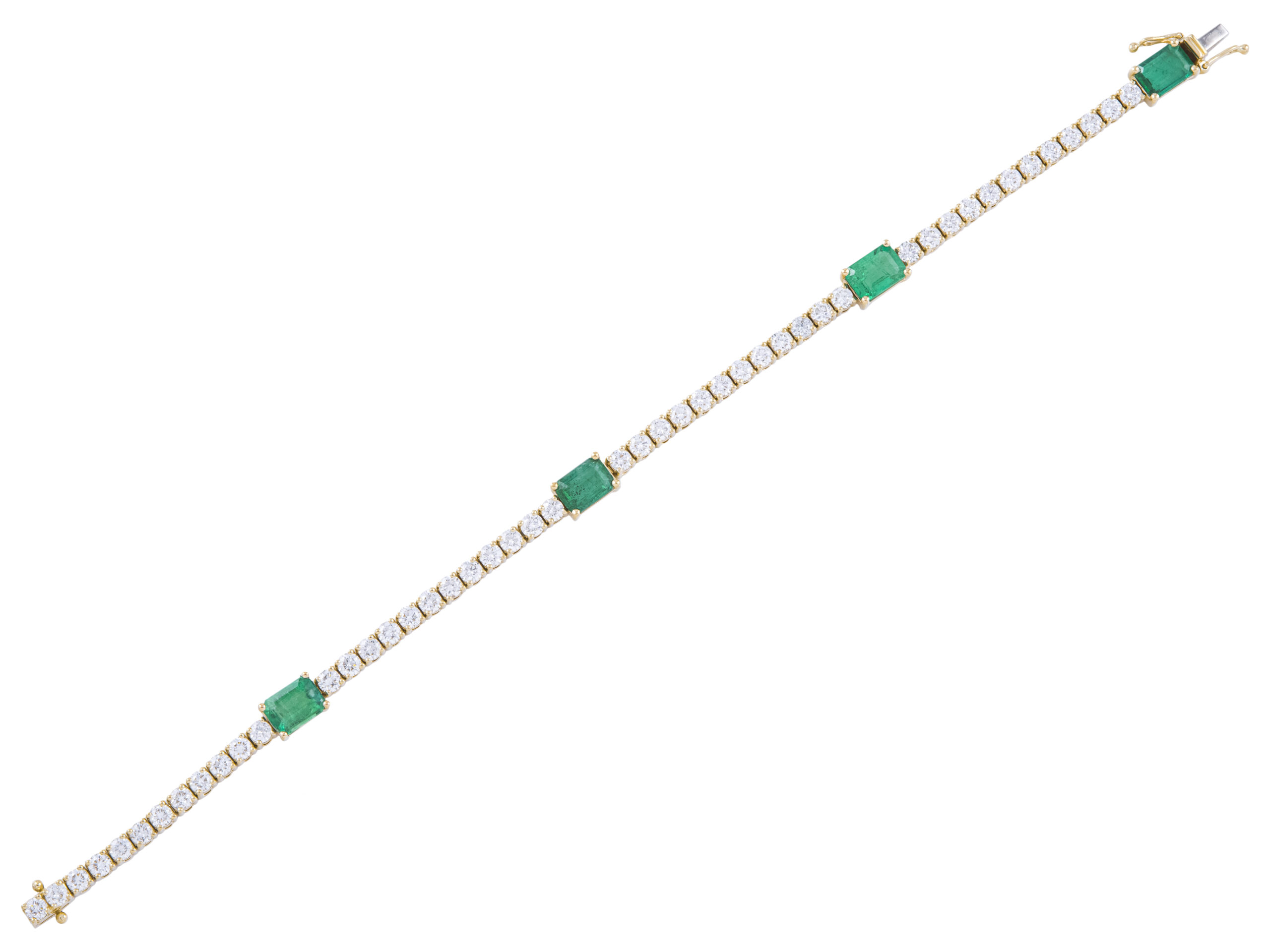Emerald and diamond tennis bracelet on white background.