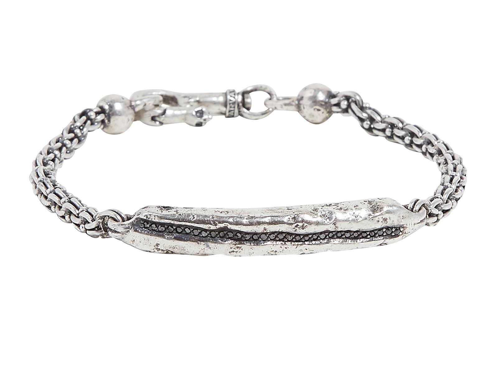 Textured silver bracelet on white background.