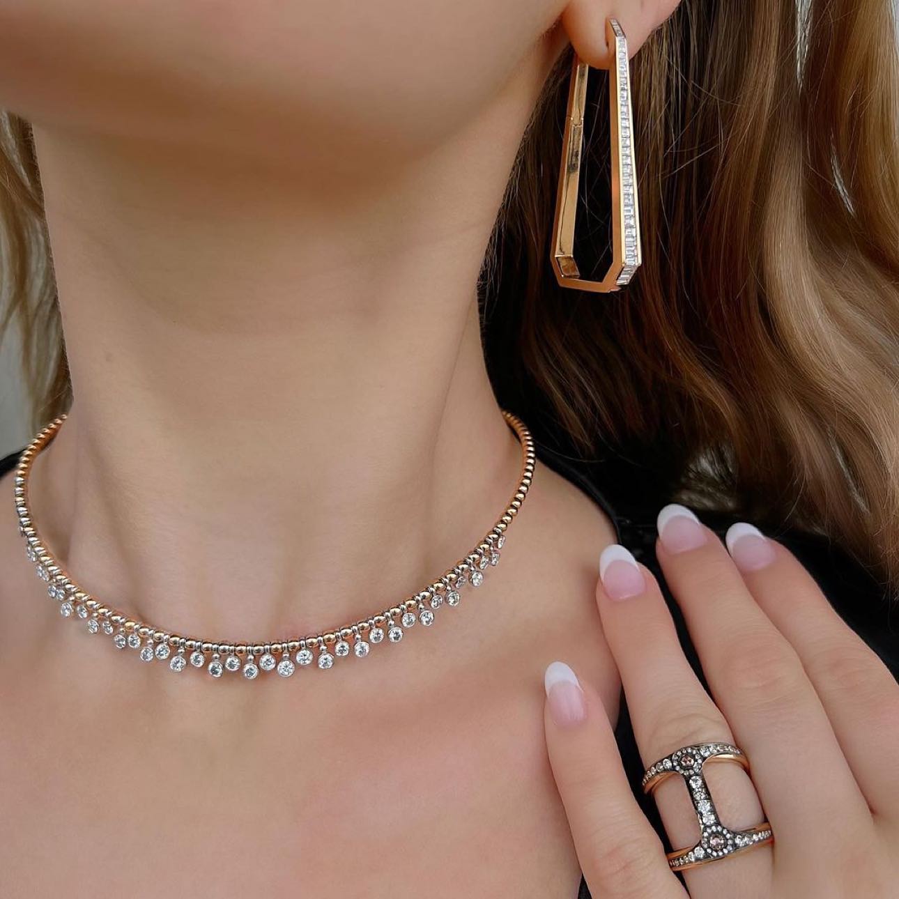 Woman wears elegant jewelry set, earrings and necklace.