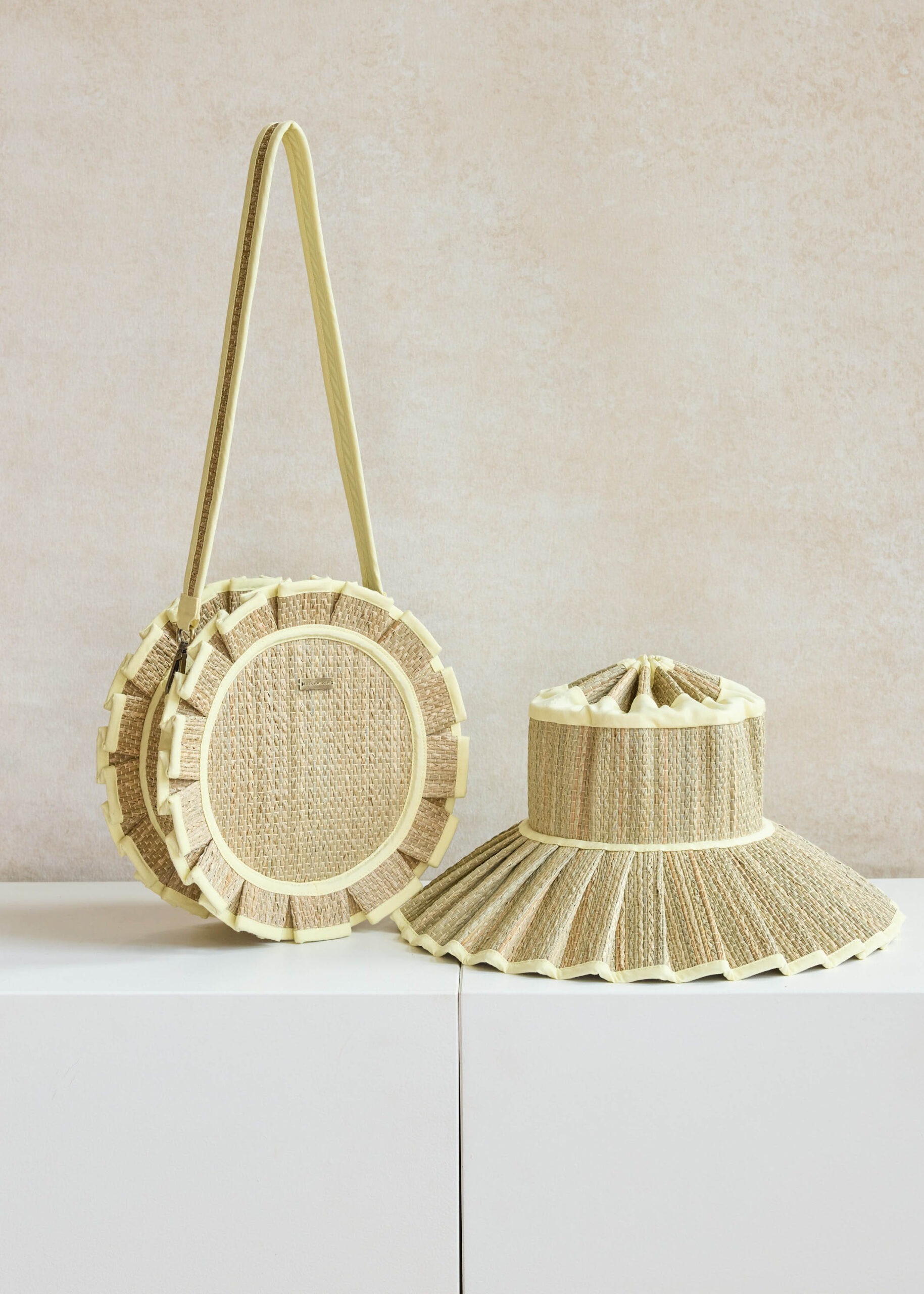 Woven bag and hat on white surface.